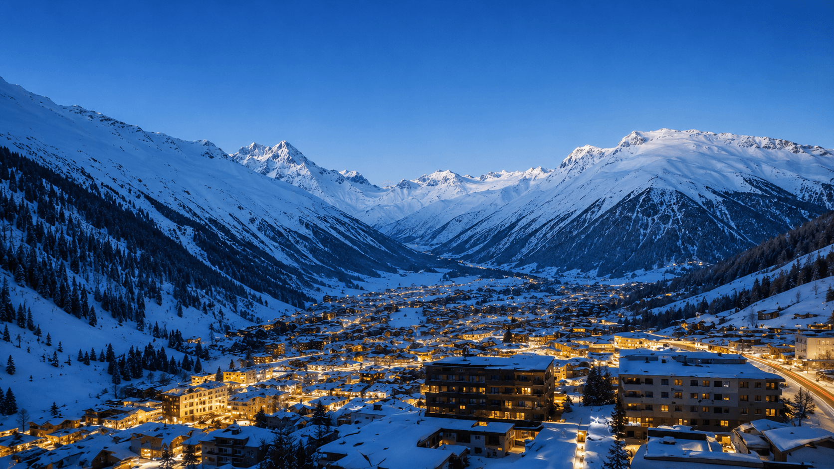 The Davos valley at dusk, with snowy mountains and town lights during World Economic Forum week.